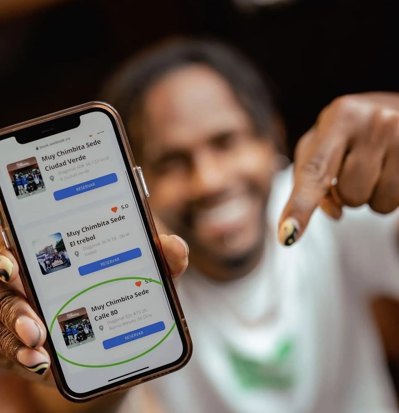 Cliente reservando horário em uma barbearia com o app da WeiBook na feira de beleza de Bogotá, na Colômbia