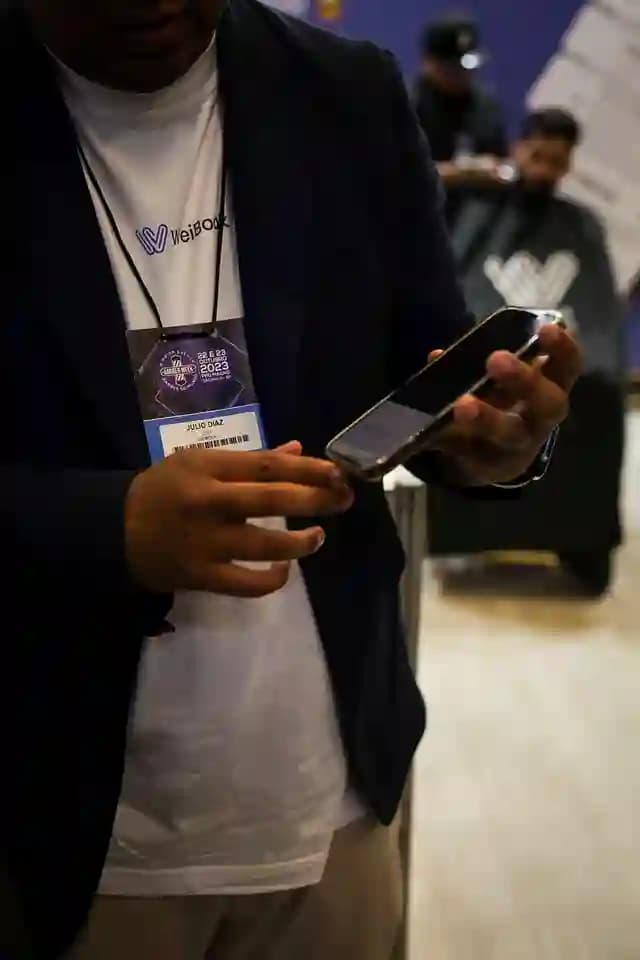 Participante com credencial da Barber Week São Paulo 2023 usando o app da WeiBook