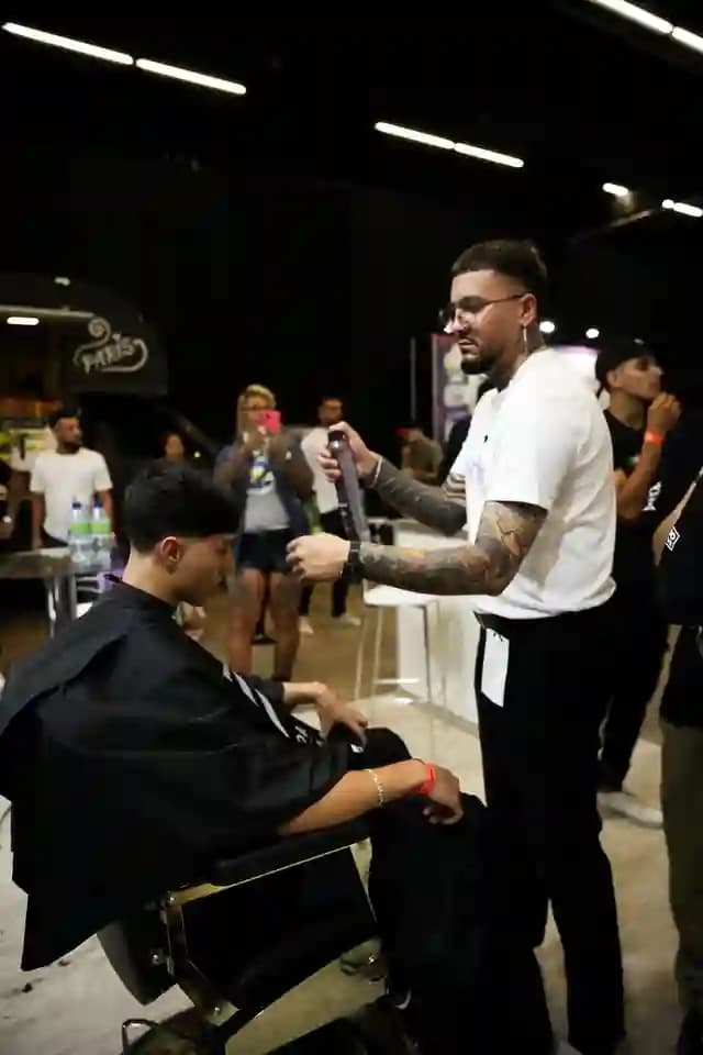 Barbeiro fazendo um corte ao vivo na Barber Week de São Paulo, Brasil, com a WeiBook