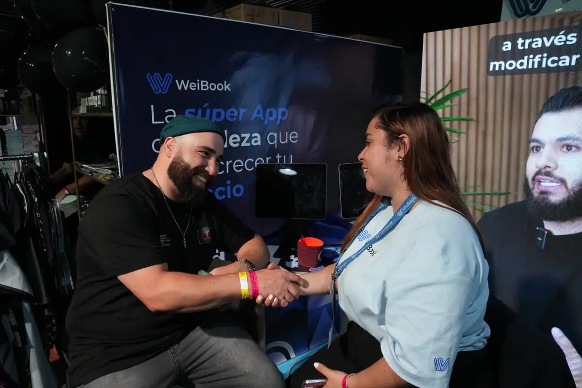 Cliente cumprimenta uma consultora da WeiBook em uma feira na Argentina