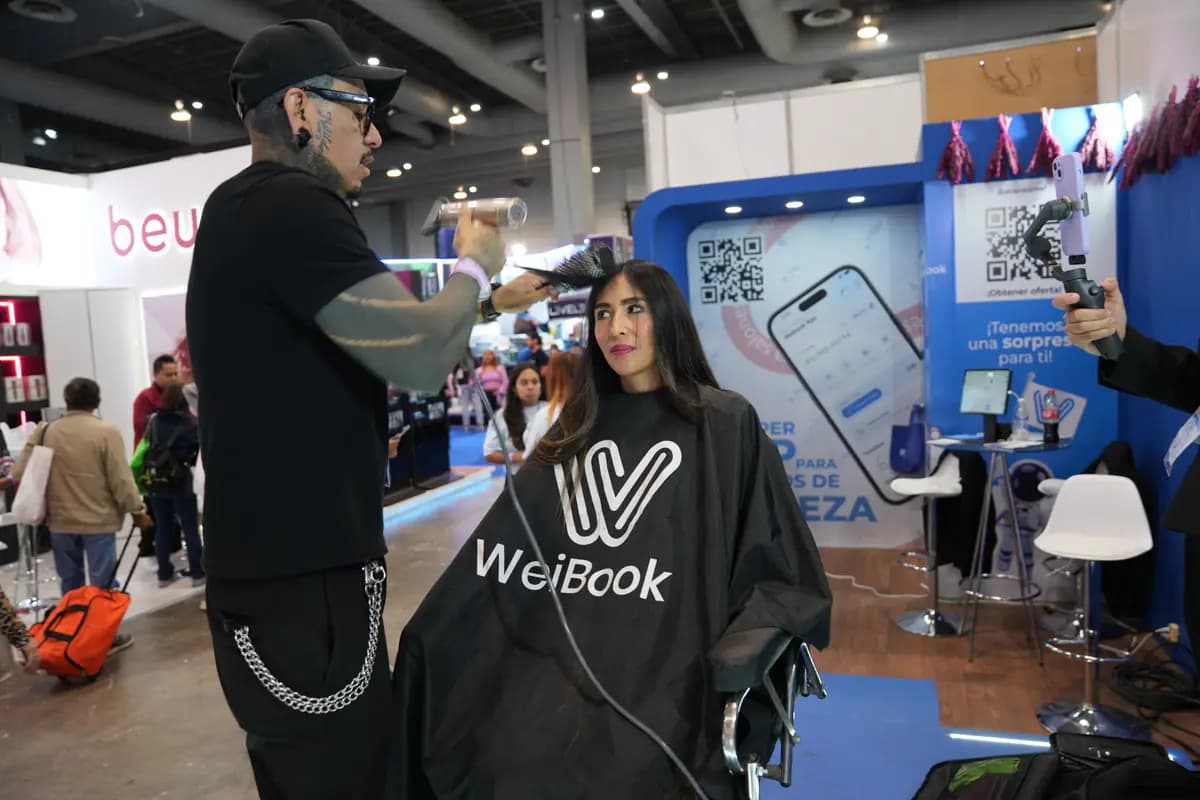 Cabeleireiro penteia uma modelo ao vivo no estande da WeiBook no México